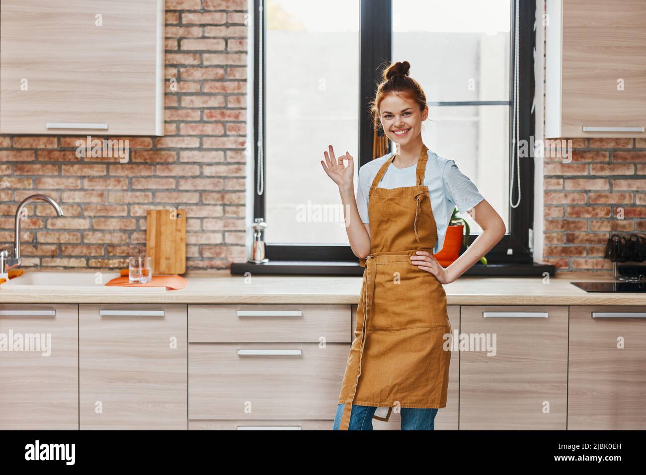 bella donna in una bruna grembiule cucina interna vita domestica Foto stock  - Alamy