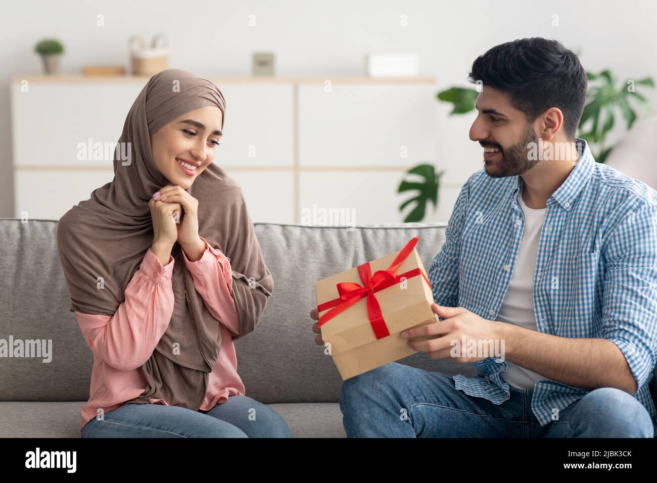 Marito musulmano che dà la scatola del regalo alla moglie sorpresa a casa  Foto stock - Alamy