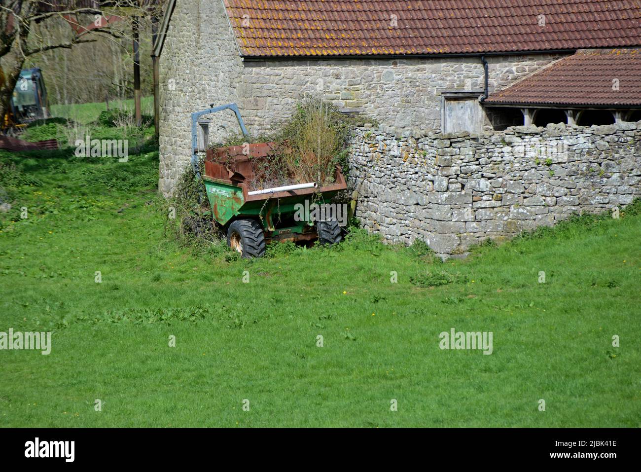 Un dumper troppo cresciuto e arrugginito abbandonato in una fattoria a Tintern, Gloucestershire Foto Stock