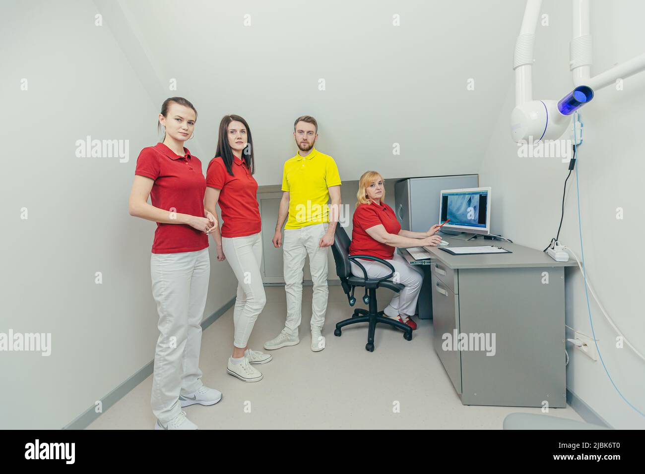 Incontro dei dentisti. Medici e assistenti esaminano i raggi X dei denti e delle mandibole del paziente sul computer, discutono il trattamento in ufficio Foto Stock