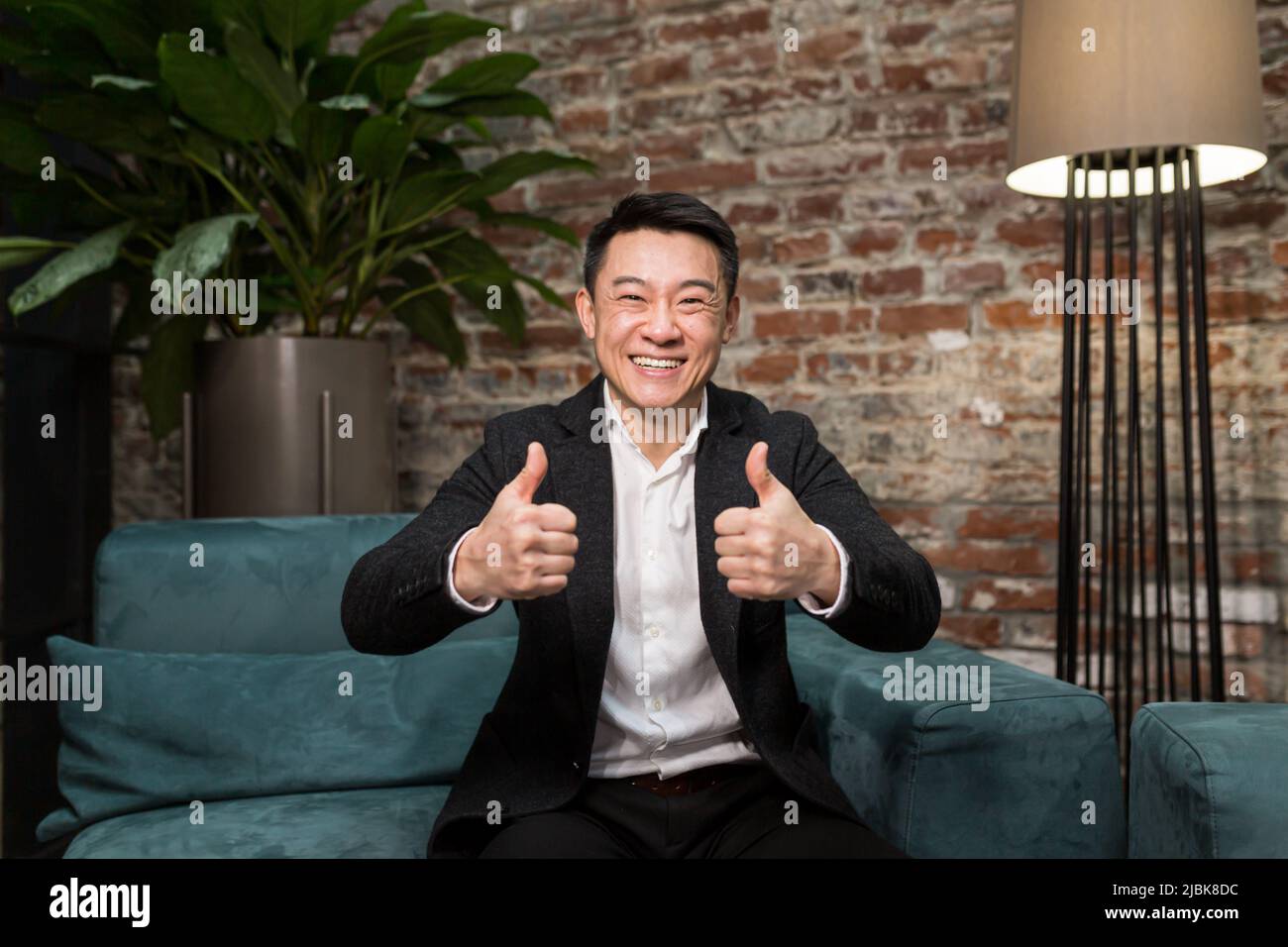 Eccitato giovane uomo d'affari asiatico sensazione felice di ricevere nuova opportunità di lavoro, premio bonus, celebra il concetto di crescita del mercato finanziario stupito uomo shoc Foto Stock