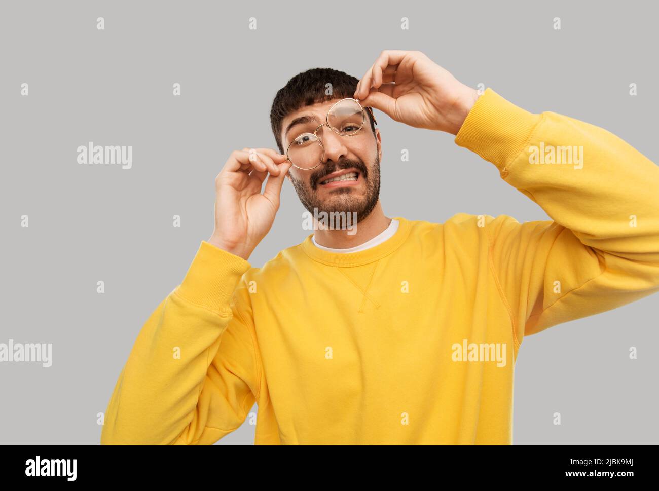 gofy giovane uomo in occhiali e felpa gialla Foto Stock