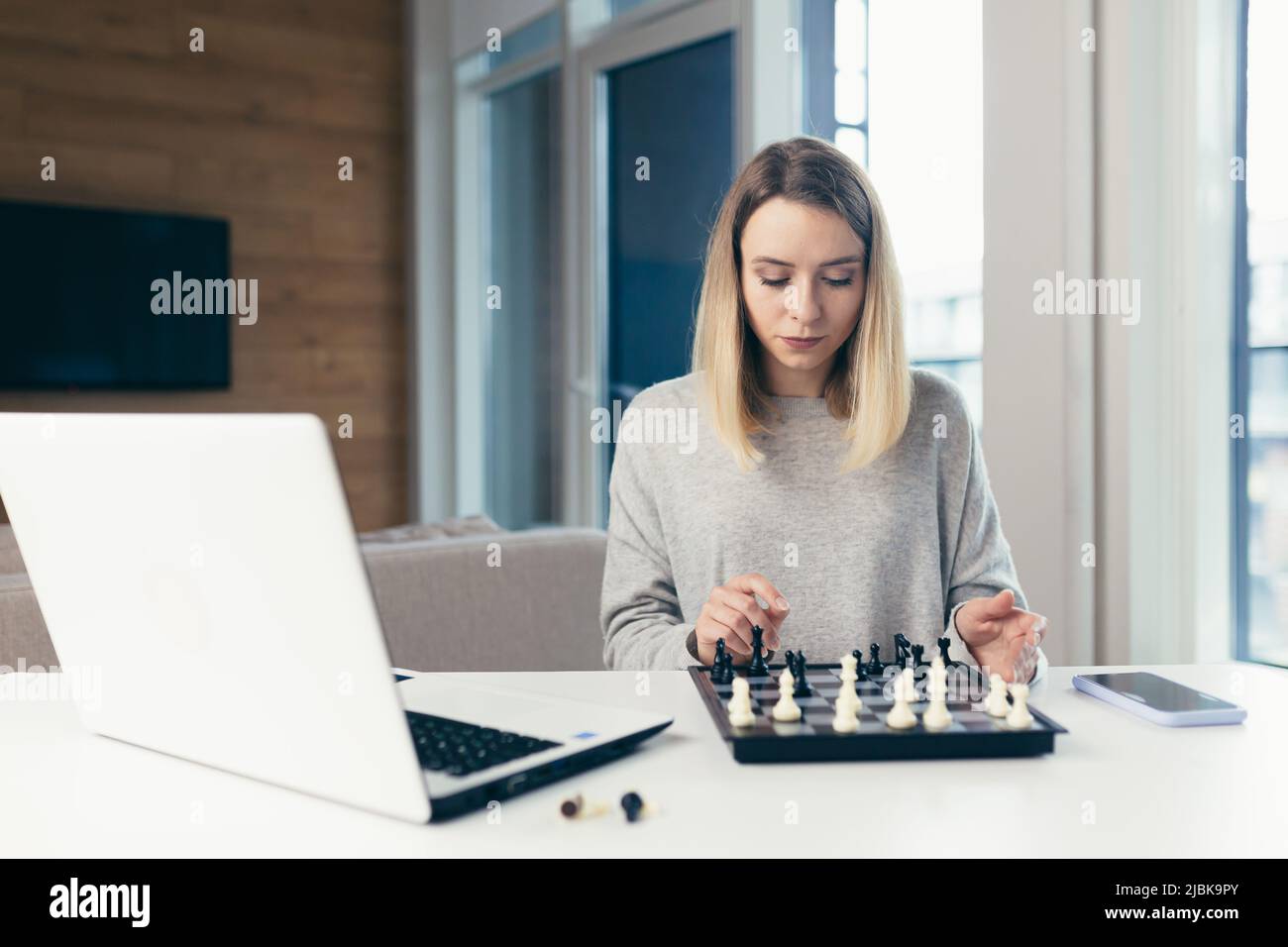 Ritratto di giovane bella donna che gioca a scacchi online via computer  portatile a casa, studiare, pensare, concorrenza, quarantena Foto stock -  Alamy