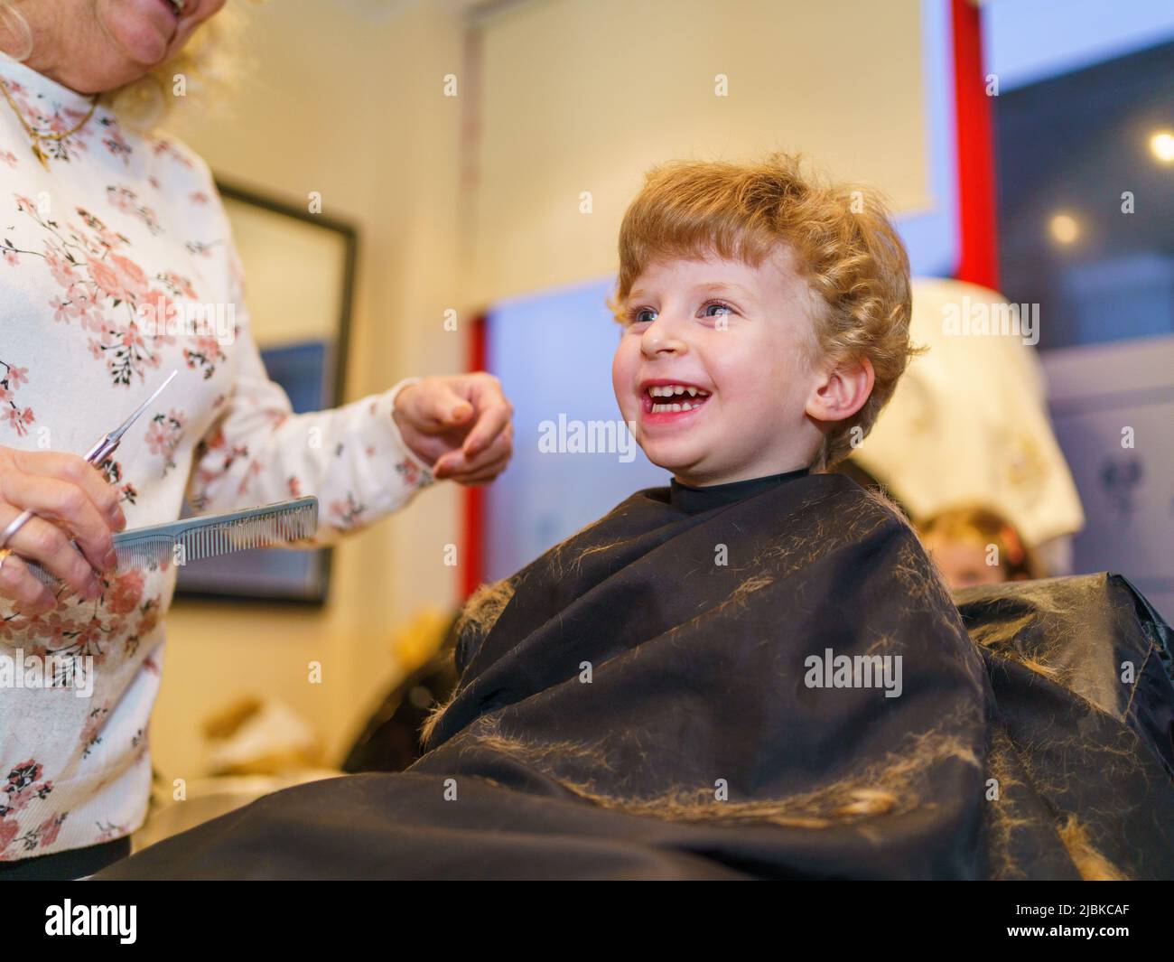 Ragazzo di due anni che ha un taglio dei capelli al parrucchiere, UK Foto Stock