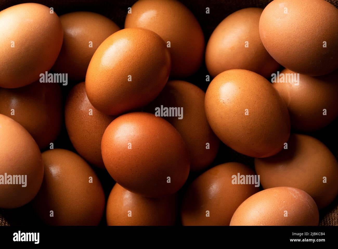 Uova di gallina rossa su tavola rustica scura, ingredienti biologici del cibo Foto Stock