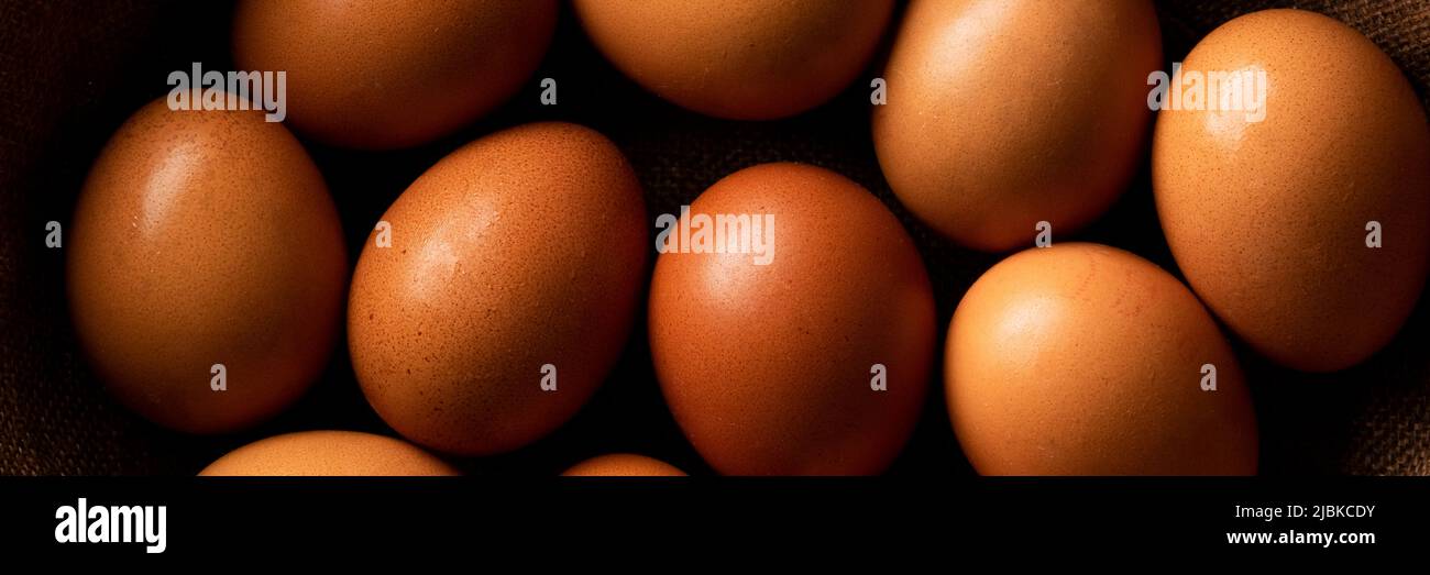 Uova di gallina rossa su tavola rustica scura, ingredienti biologici del cibo Foto Stock