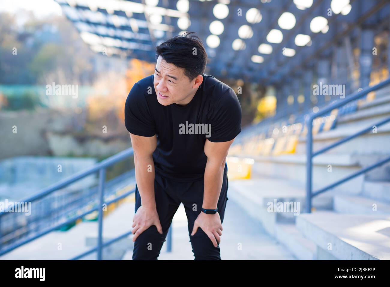 L'atleta asiatico ha una grave mancanza di respiro dopo l'allenamento, respira un battito cardiaco veloce, dopo l'allenamento Foto Stock