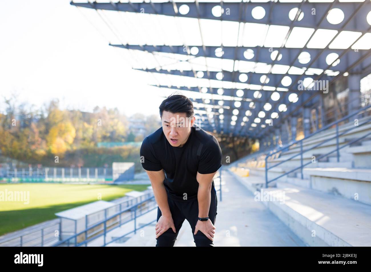 L'atleta asiatico ha una grave mancanza di respiro dopo l'allenamento, respira un battito cardiaco veloce, dopo l'allenamento Foto Stock