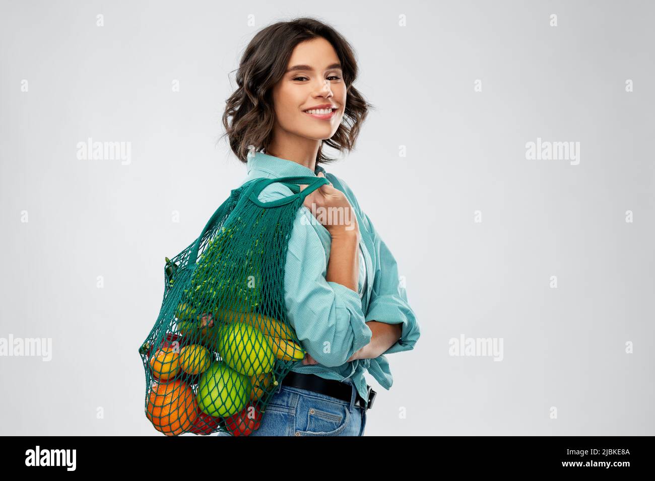 donna sorridente felice con cibo in sacchetto riutilizzabile Foto Stock