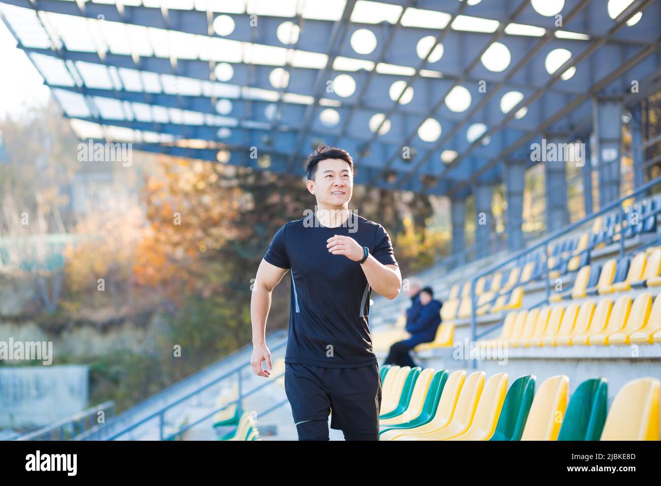 Asian maschio runner correre intorno moderno stadio urbano su scale cardio mattina Jog arrampicata uomo scala jogging Outdoor. sport uomo atleta allenamento i Foto Stock