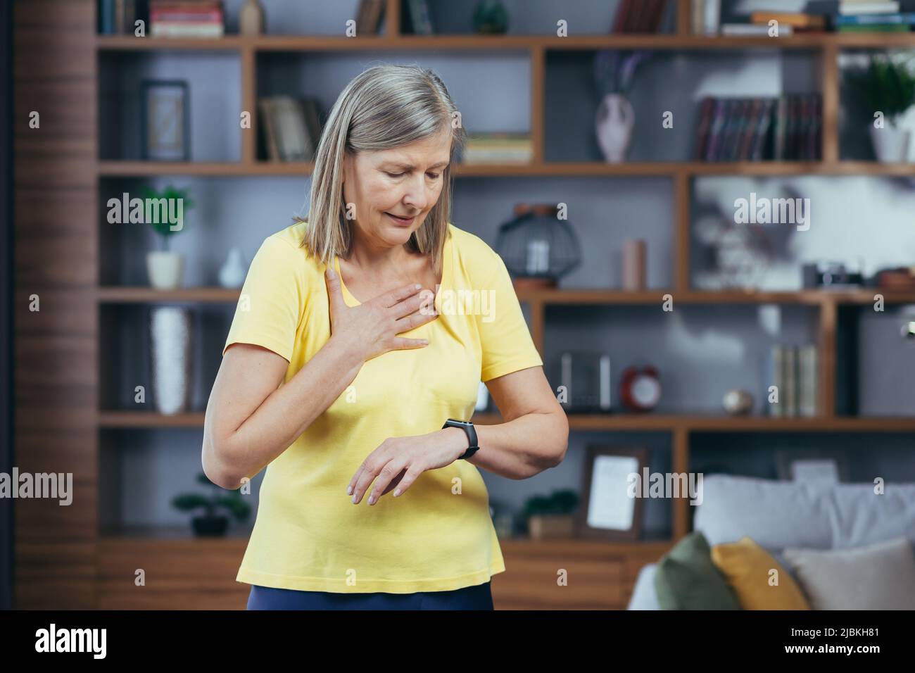 La donna più anziana nel paese che fa il fitness ha una grave mancanza di respiro e dolore toracico, confronta le pallottole sui braccialetti fitness Foto Stock
