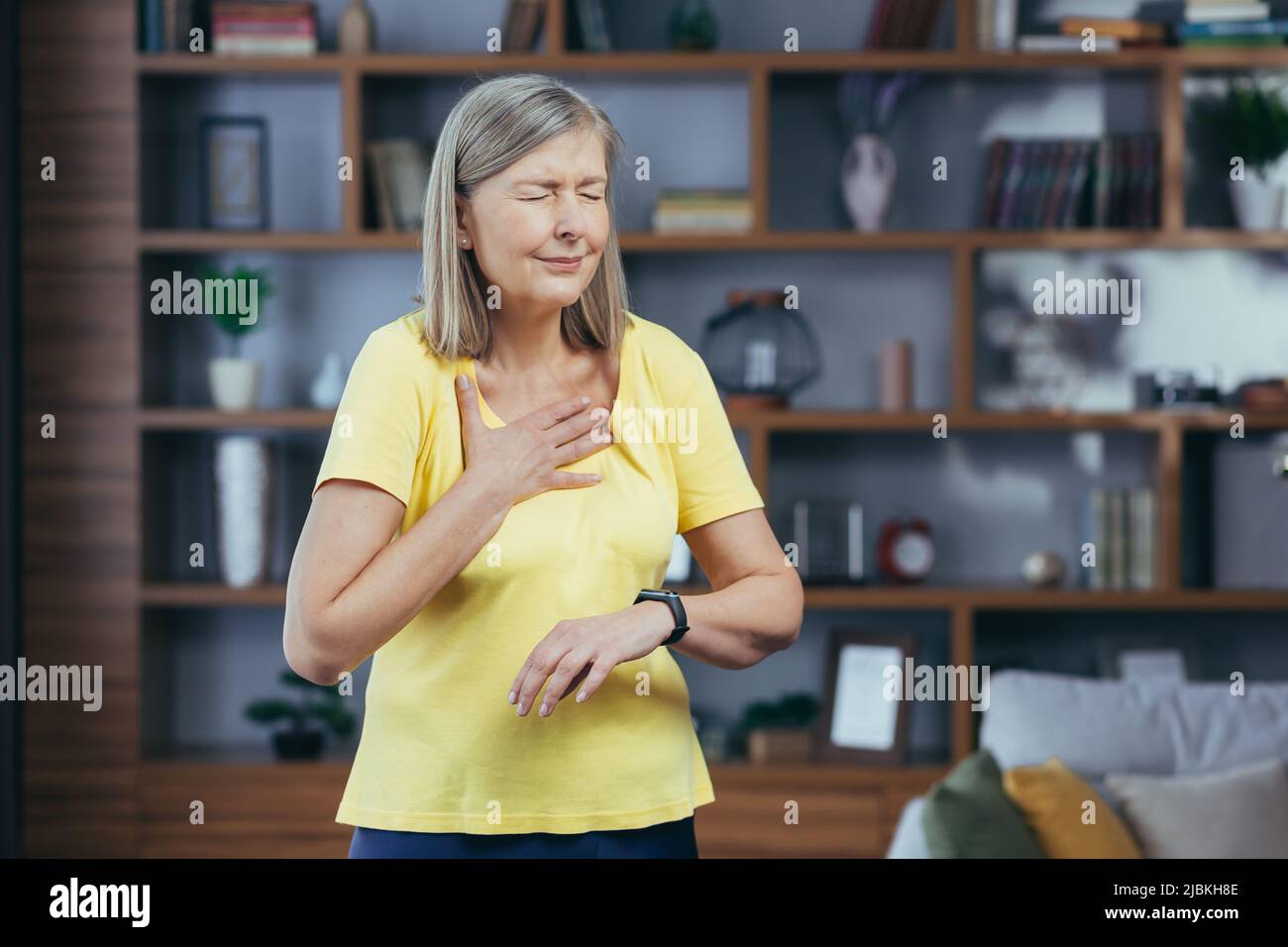 La donna più anziana nel paese che fa il fitness ha una grave mancanza di respiro e dolore toracico, confronta le pallottole sui braccialetti fitness Foto Stock