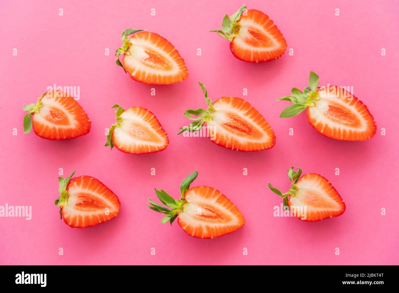 Piatto con fragole tagliate su sfondo rosa Foto Stock