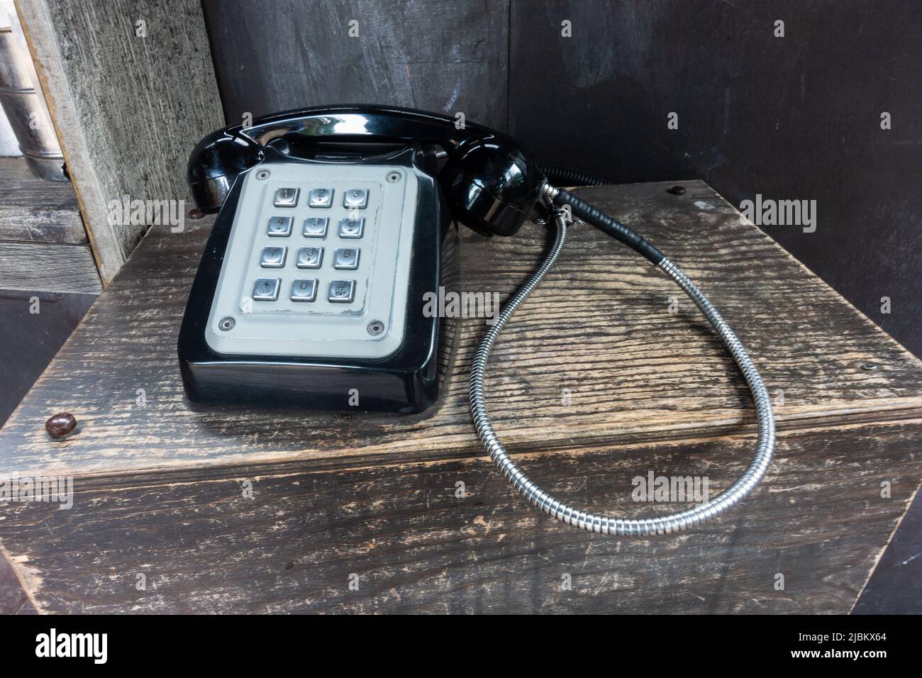 Un vecchio stile, telefono vintage con una cornetta fissata a una base tramite un cavo forma parte di un display al London Zoo Foto Stock
