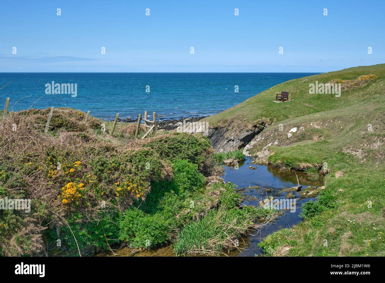 Un ruscello percorra la costa settentrionale della penisola di Llyn fino al mare dal Wales Coast Path Foto Stock