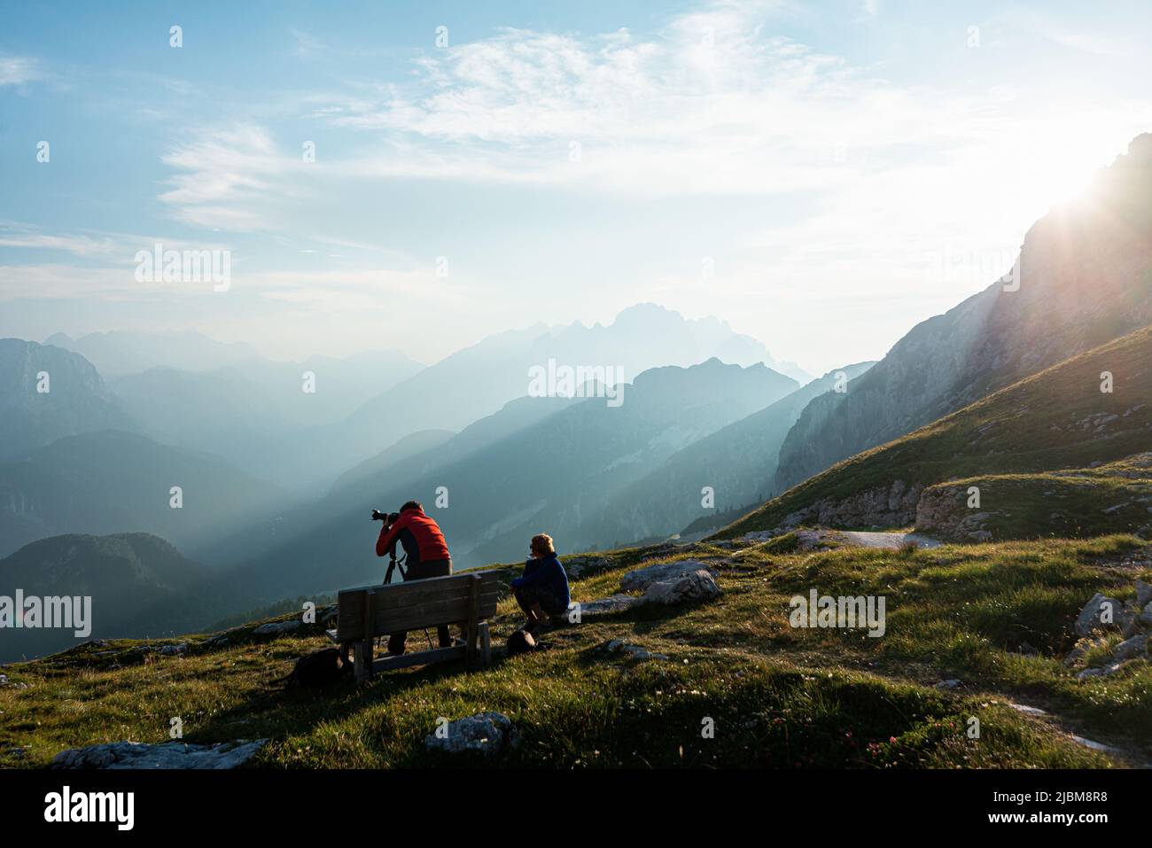 Fotografo di viaggio che cattura paesaggi ipnotici nella valle di Kamnik in slovenia, con l'aiuto di un assistente Foto Stock