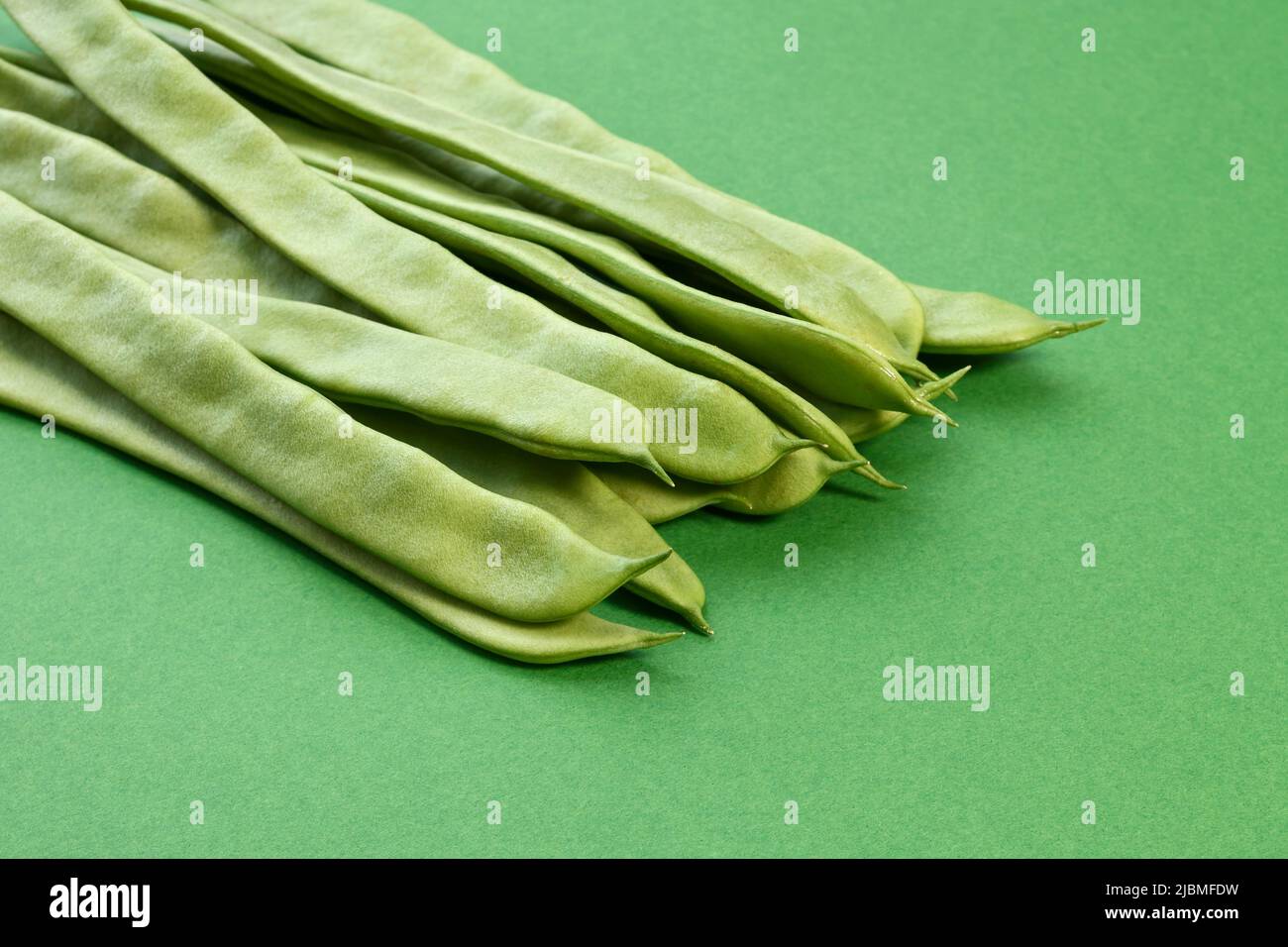 Un mucchio di fagioli runner su sfondo verde Foto Stock