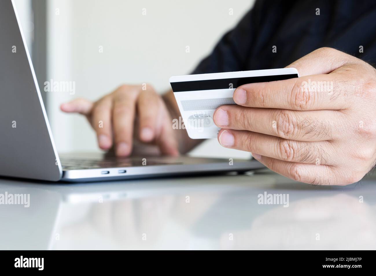 Con carta di credito, mano dell'uomo con carta di credito e tastiera del computer portatile. Uomo caucasico shopping online. Digitare i dati della carta di credito in e-Comme Foto Stock