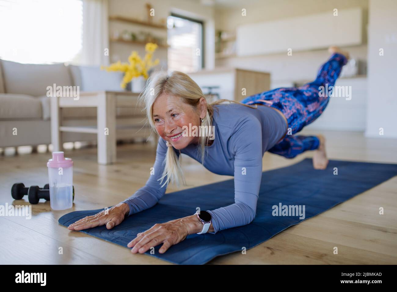 Misura la donna anziana che fa l'esercitazione di workout a casa, concetto attivo di lifestyle. Foto Stock