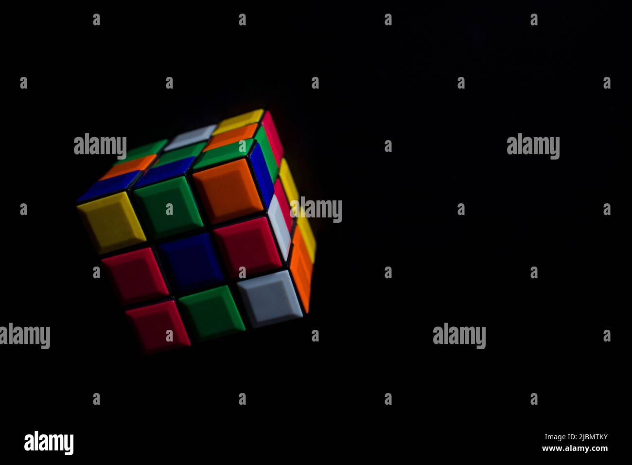 caduta cubo di rubik su nero. puzzle concetto. cervello ridle Foto Stock