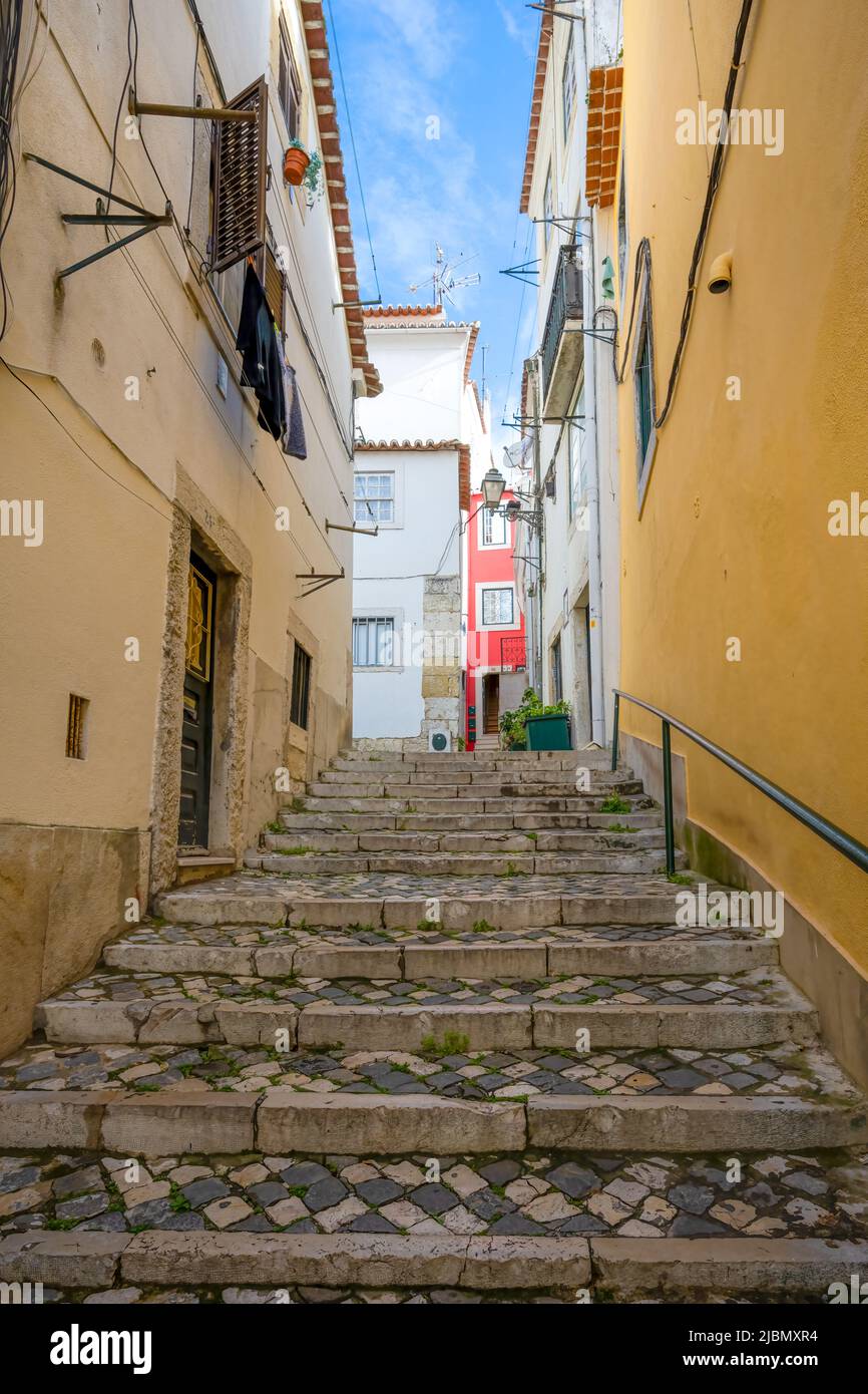 Un'attraente strada acciottolata si trova tra file di vecchie case nel centro di Lisbona, capitale del Portogallo Foto Stock