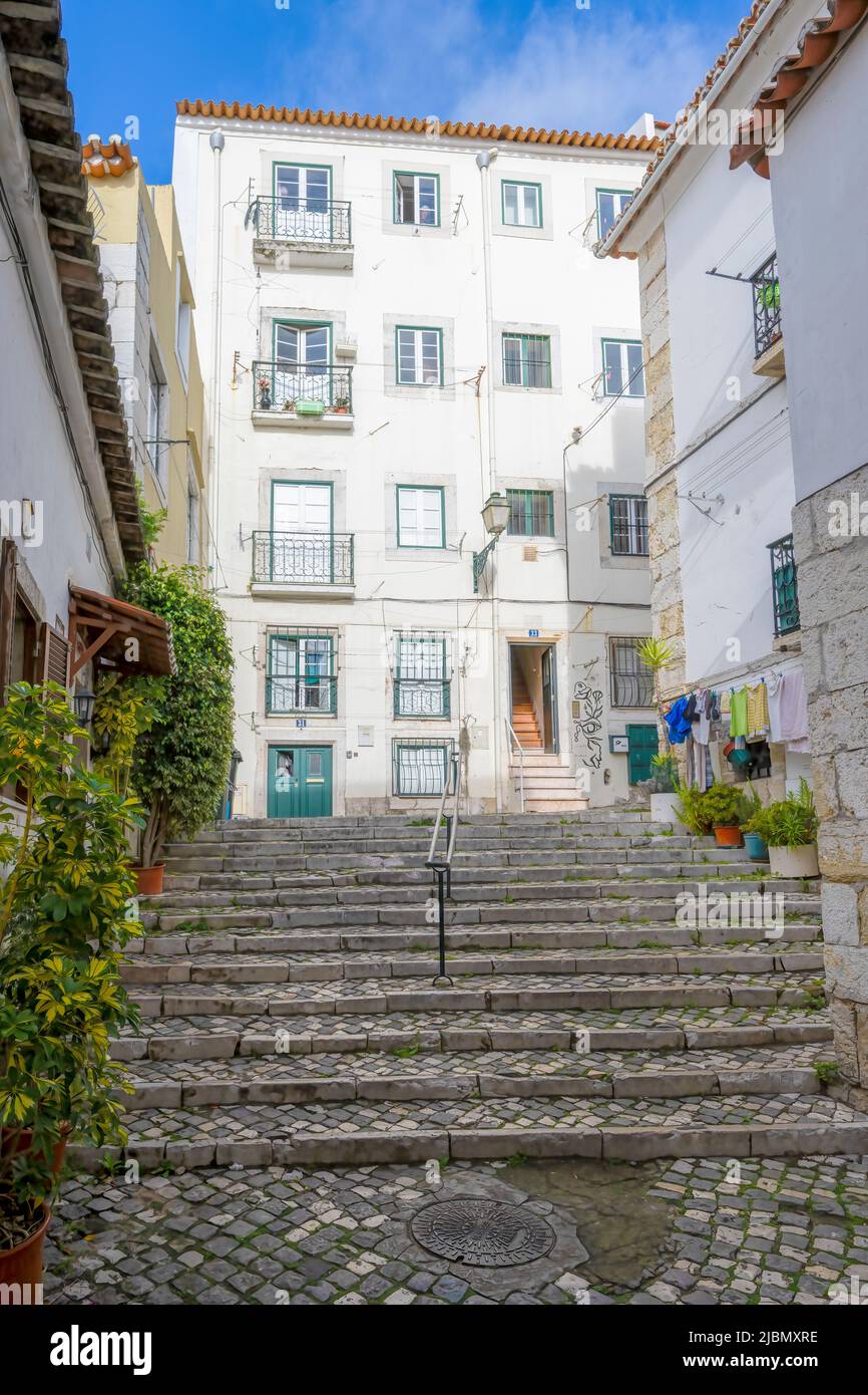 Un'attraente strada acciottolata si trova tra file di vecchie case nel centro di Lisbona, capitale del Portogallo Foto Stock