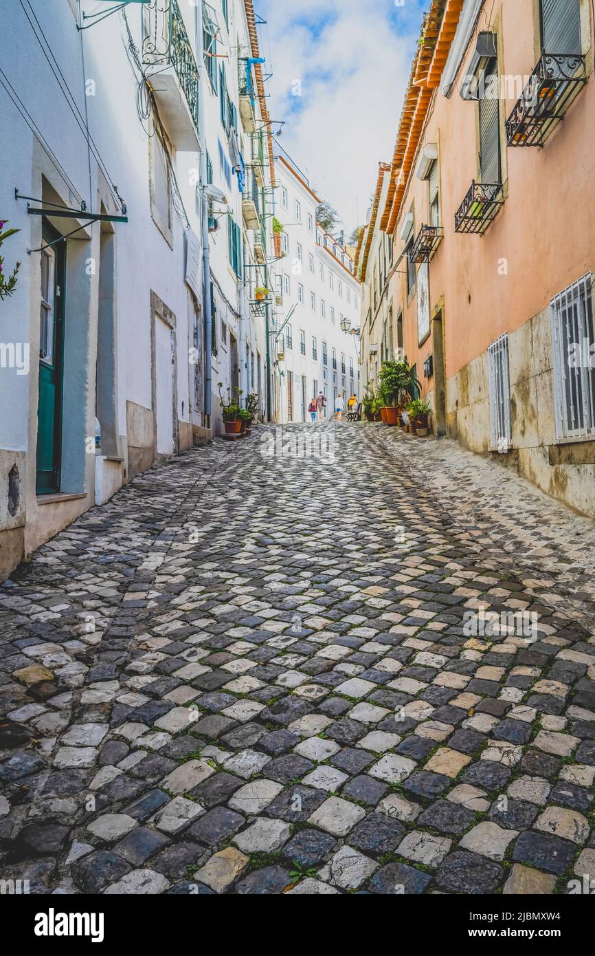 Un'attraente strada acciottolata si trova tra file di vecchie case nel centro di Lisbona, capitale del Portogallo Foto Stock