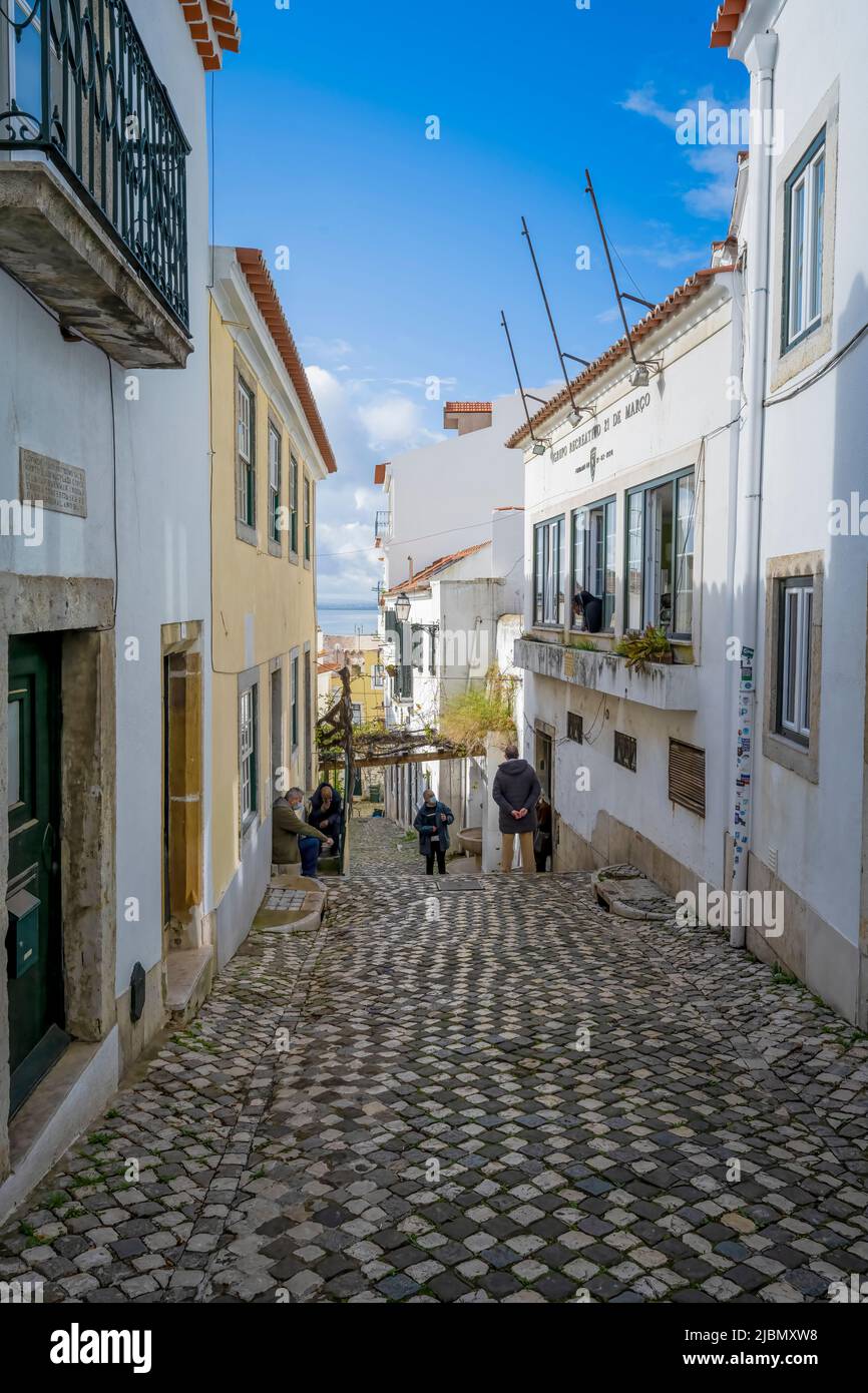 Un'attraente strada acciottolata si trova tra file di vecchie case nel centro di Lisbona, capitale del Portogallo Foto Stock