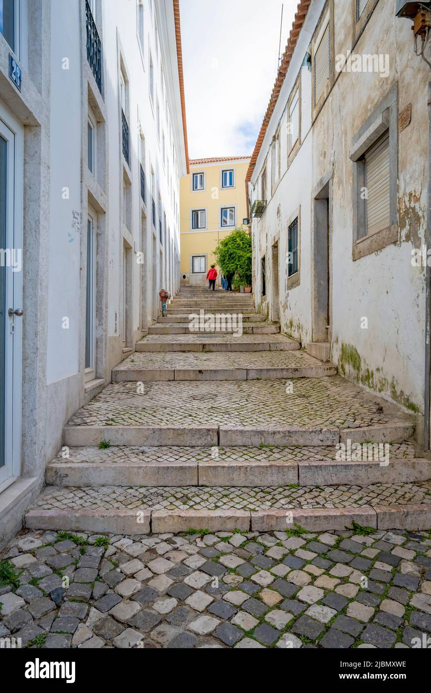 Un'attraente strada acciottolata si trova tra file di vecchie case nel centro di Lisbona, capitale del Portogallo Foto Stock