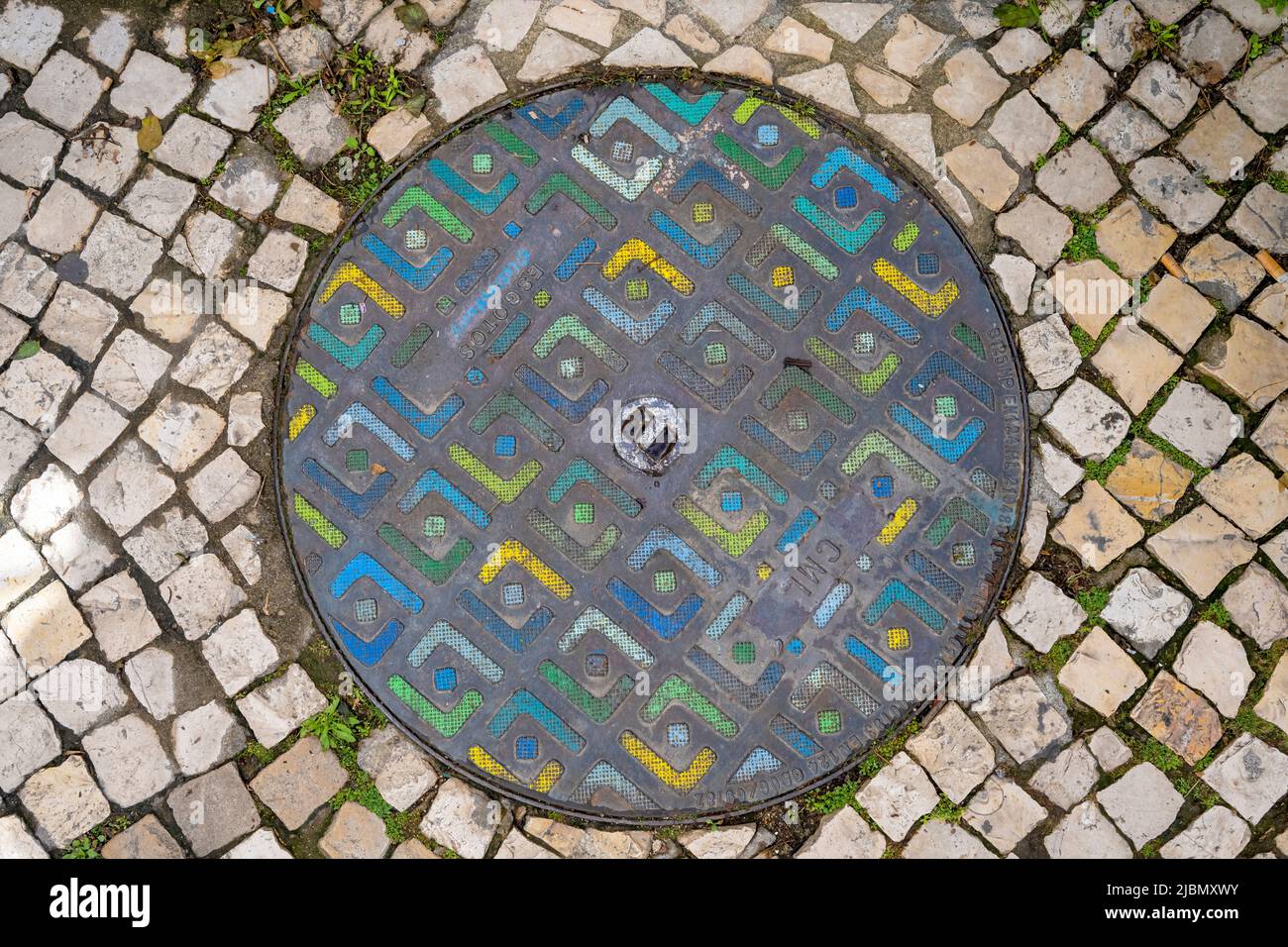 Una colorata botola in una strada lastricata nel centro di Lisbona, capitale del Portogallo Foto Stock