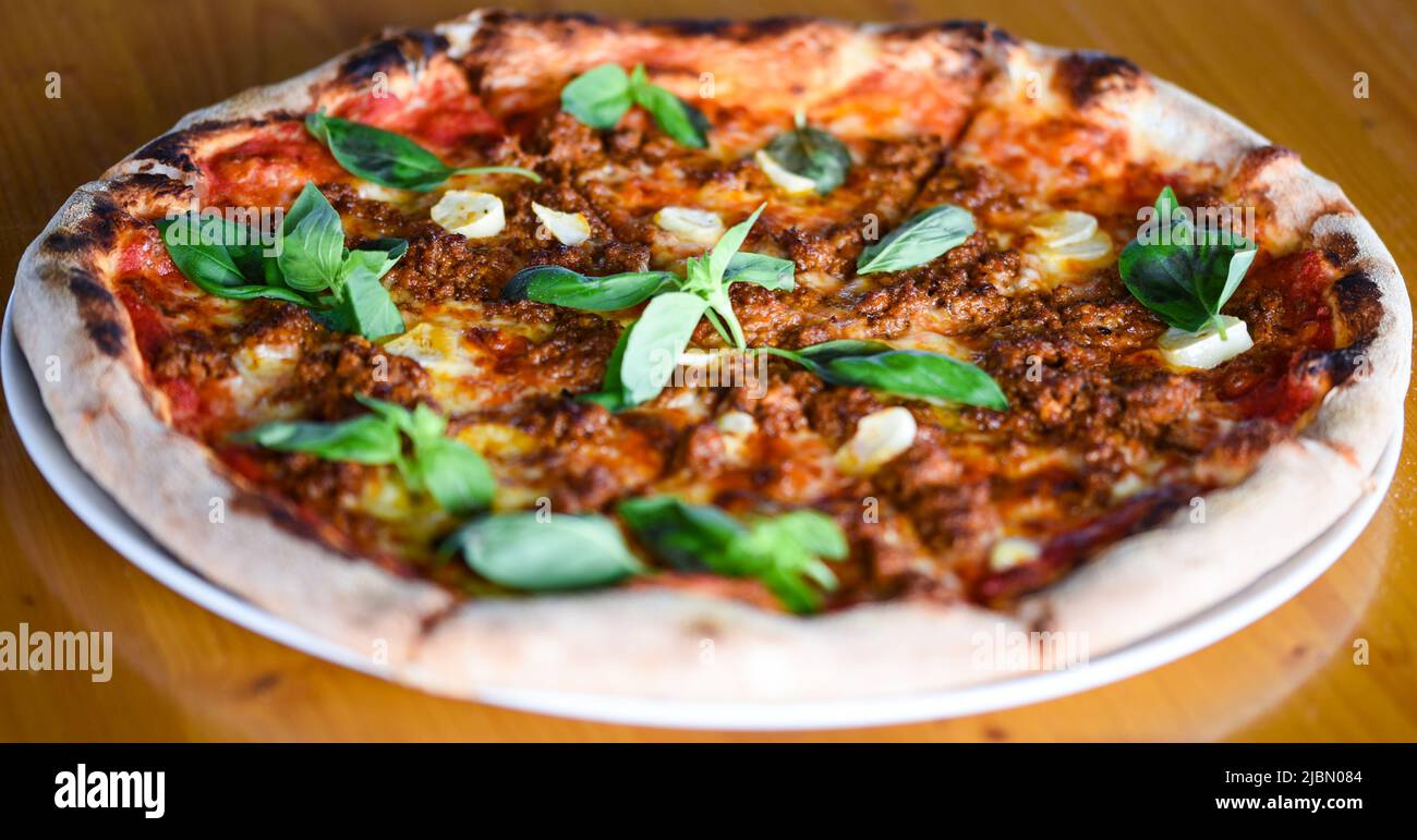 gustosa pizza bolognese con basilico fresco Foto Stock