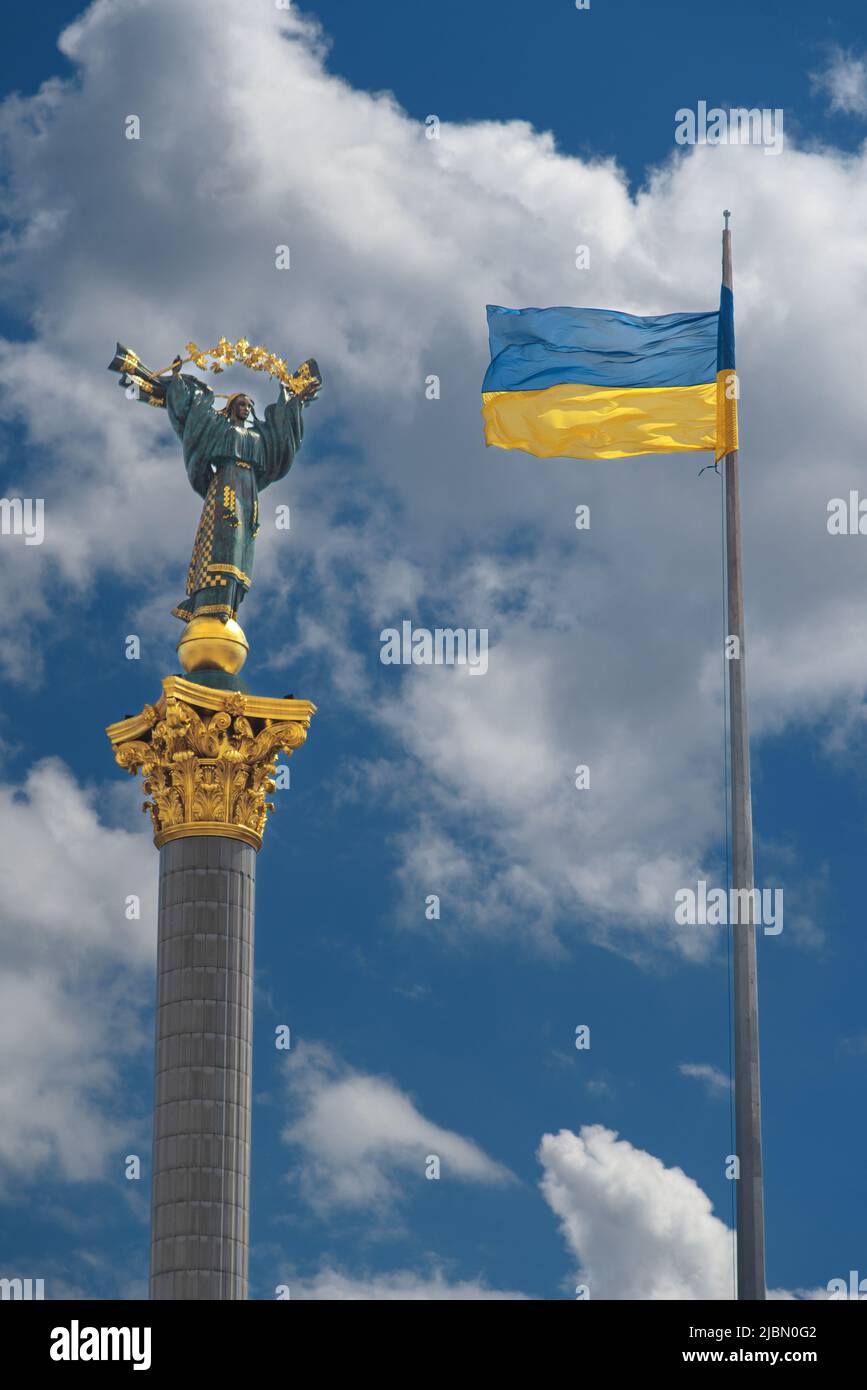 Monumento dell'Indipendenza a Kiev e bandiera ucraina contro il cielo blu con nuvole bianche Foto Stock