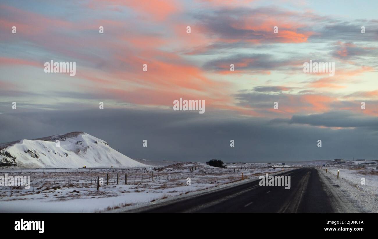 Un tramonto islandese sulle montagne e sulla strada Foto Stock