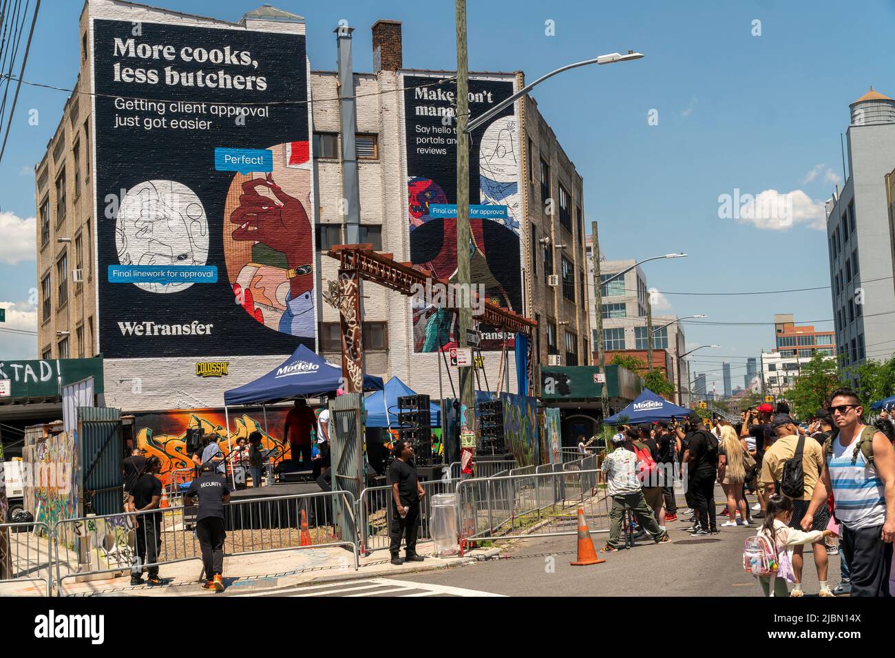 La pubblicità per WeTransfer incombe su Bushwick, Brooklyn a New York durante l'annuale Bushwick Collective Block Party sabato 4 giugno 2022. La musica e la festa hanno portato alcuni, ma la vera attrazione è stata i nuovi murali di artisti 'graffiti' che decorano le pareti degli edifici che il collettivo utilizza. (© Richard B. Levine) Foto Stock