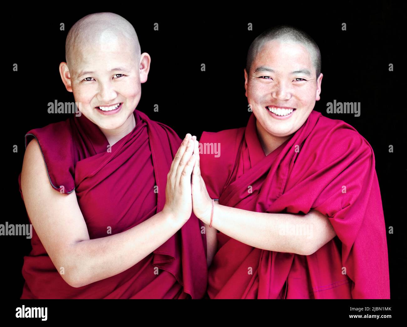 Ritratto di due suore buddiste tibetane che danno un segno di pace condiviso. McLeod Ganj, Dharamsala, India. Foto Stock