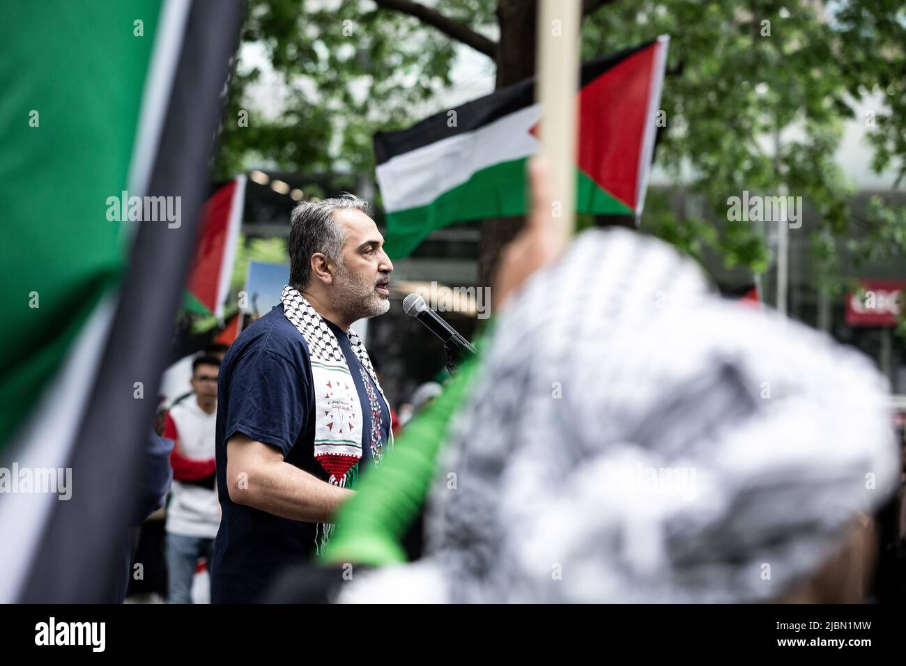 Iyad Abuhamed, organizzatore dell'evento, parla durante la protesta. Foto Stock