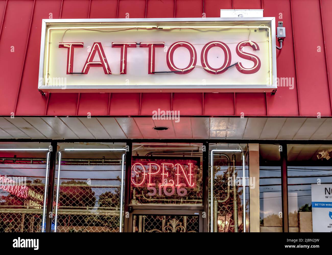 Charlotte, NC/USA - May10, 2019: Editoriale medio orizzontale di neon 'Tattoos' segno di facciata del negozio di tatuaggi con tetto rosso e neon 'Open' segno i Foto Stock