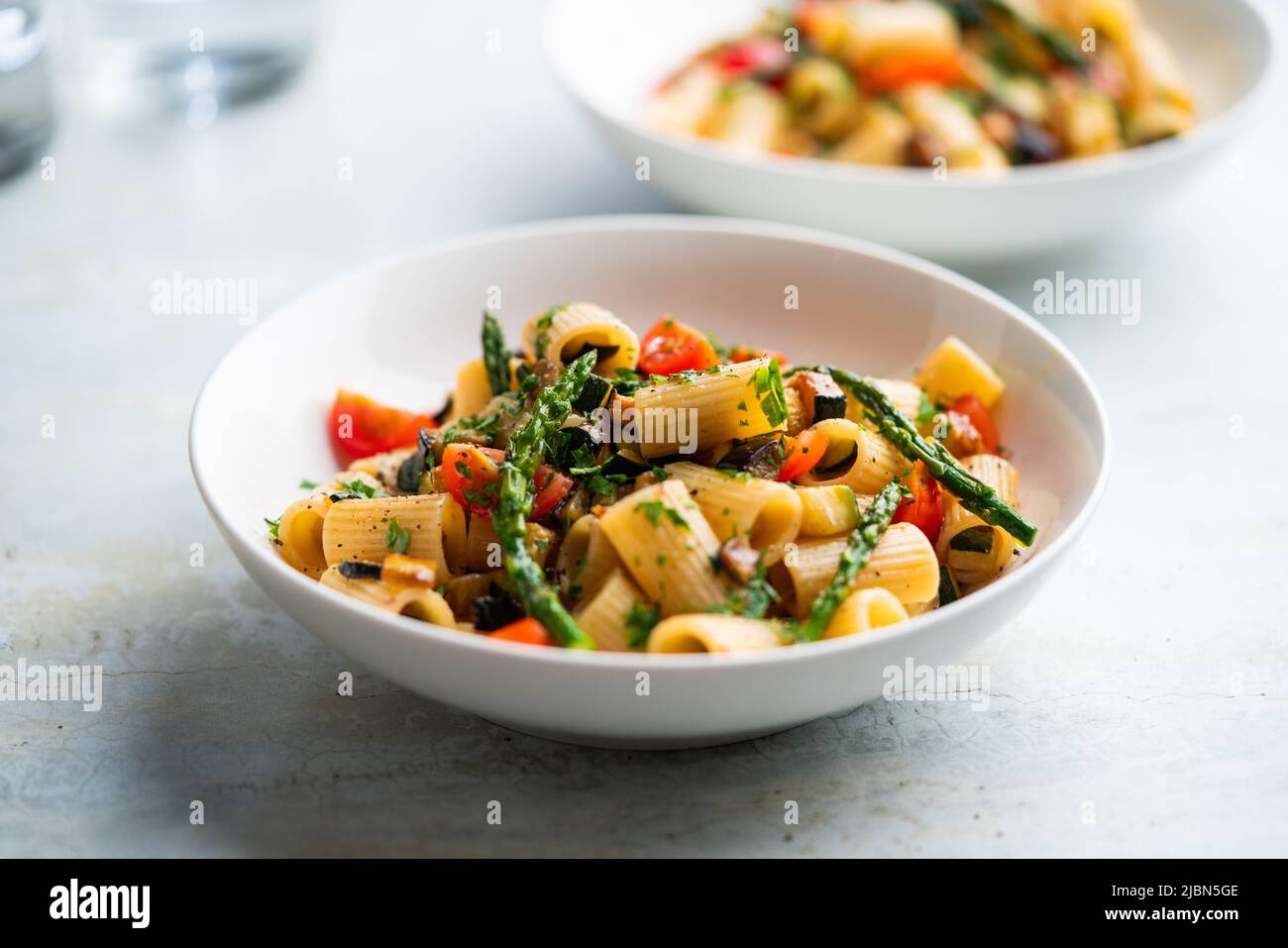 Insalata di pasta con verdure grigliate, zucchine, melanzane, asparagi e pomodori. Foto Stock