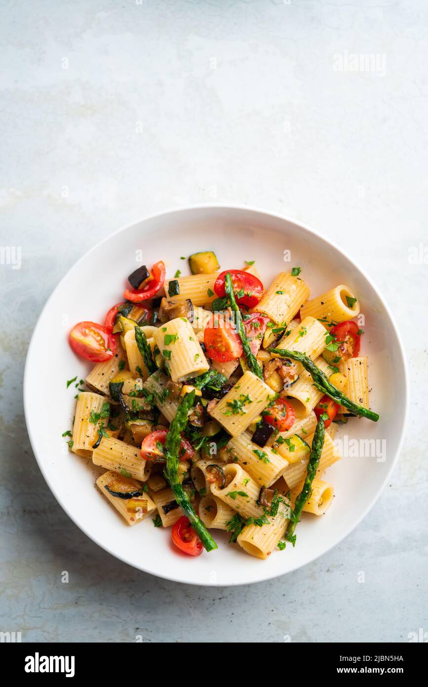 Insalata di pasta con verdure grigliate, zucchine, melanzane, asparagi e pomodori. Foto Stock