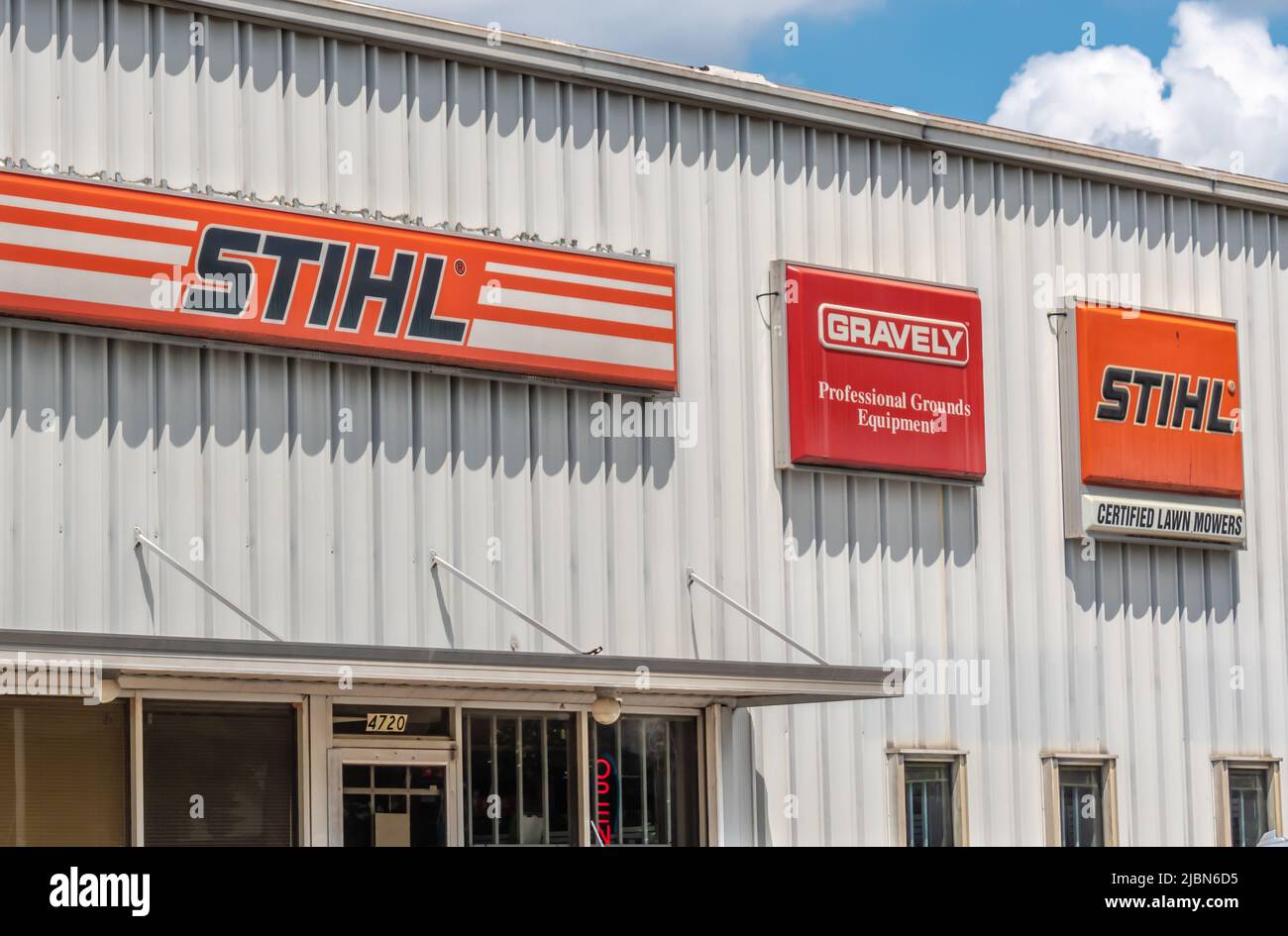 STIHL e marchiglia e logo per esterni in rosso e arancione su una facciata in metallo a coste biancastre in piena luce del sud di Charlotte, NC. Foto Stock