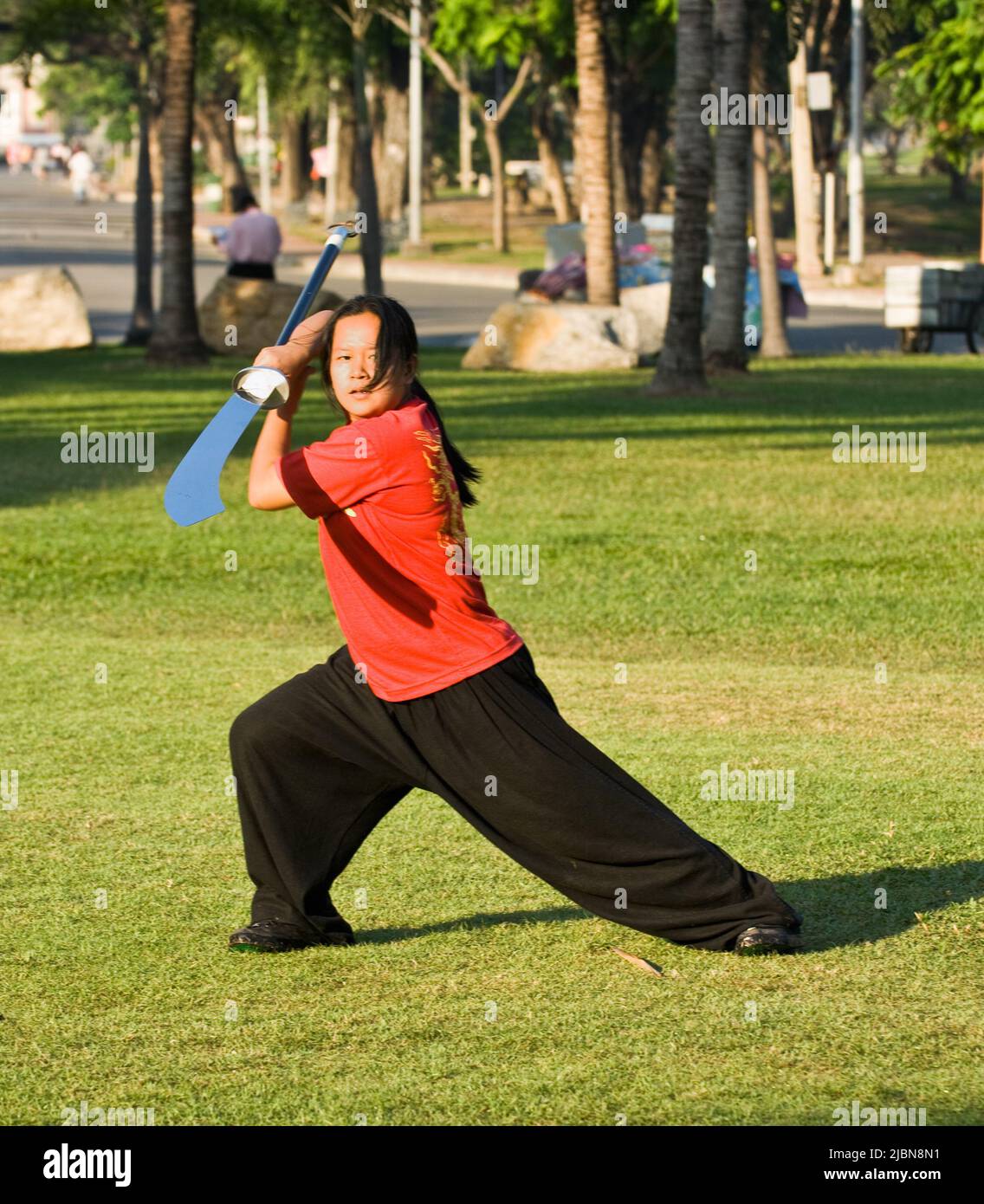 Giovane donna tailandese Tai Chi esercizio con una spada a lama nel parco Lumpini, Bangkok, Thailandia Foto Stock