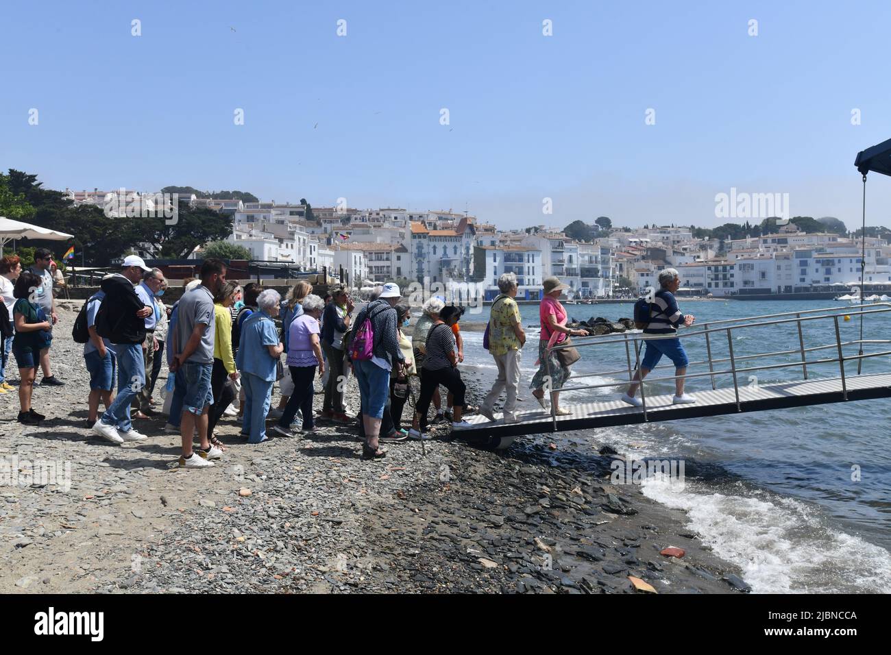 I turisti che si accaparrano a bordo di una barca a Cadaques una città spagnola nella Alt Empordà comarca, in provincia di Girona, Catalogna, Spagna. Foto Stock