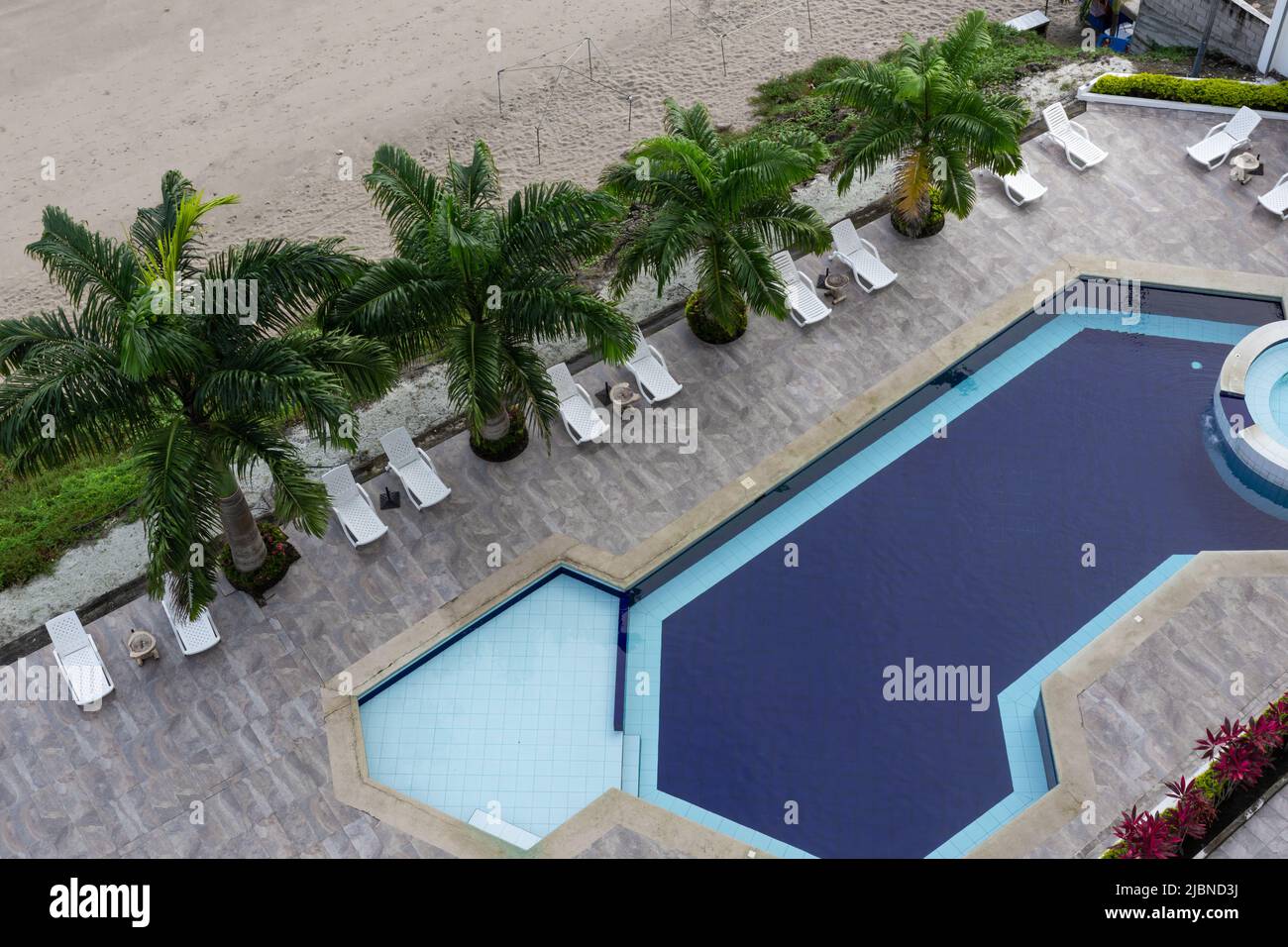 architettura esterna, vista superiore di una piscina, palme, sedie e decorazione moderna. Resort e hotel in estate, stile di vita moderno Foto Stock