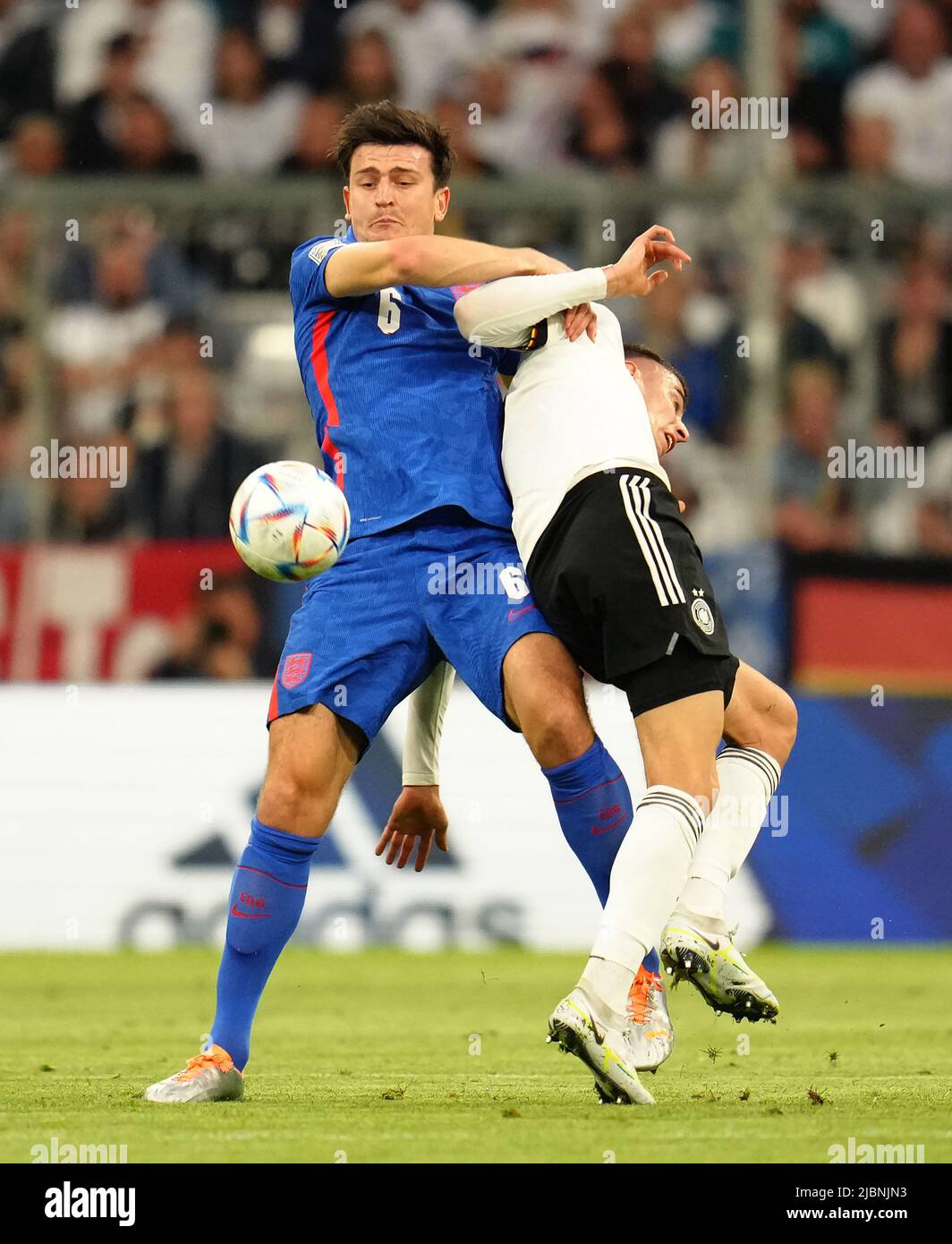 Harry Maguire in Inghilterra (a sinistra) e Kai Havertz in Germania combattono per la palla durante la partita della UEFA Nations League presso l'Allianz Arena di Monaco, in Germania. Data foto: Martedì 7 giugno 2022. Foto Stock