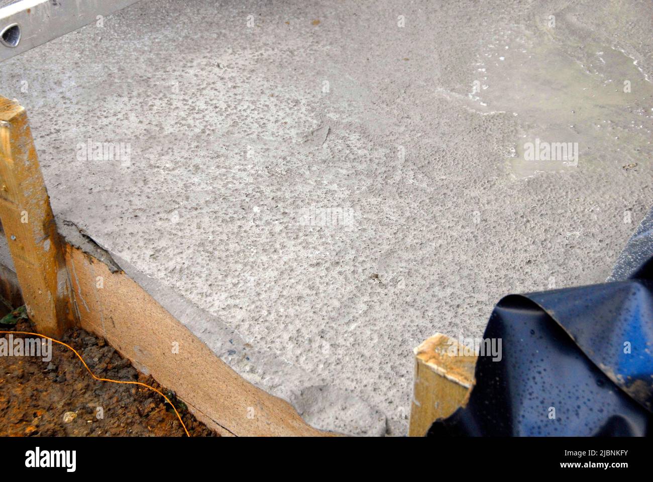 Calcestruzzo appena posato su un cantiere con segni lasciati dalla pioggia notturna Foto Stock