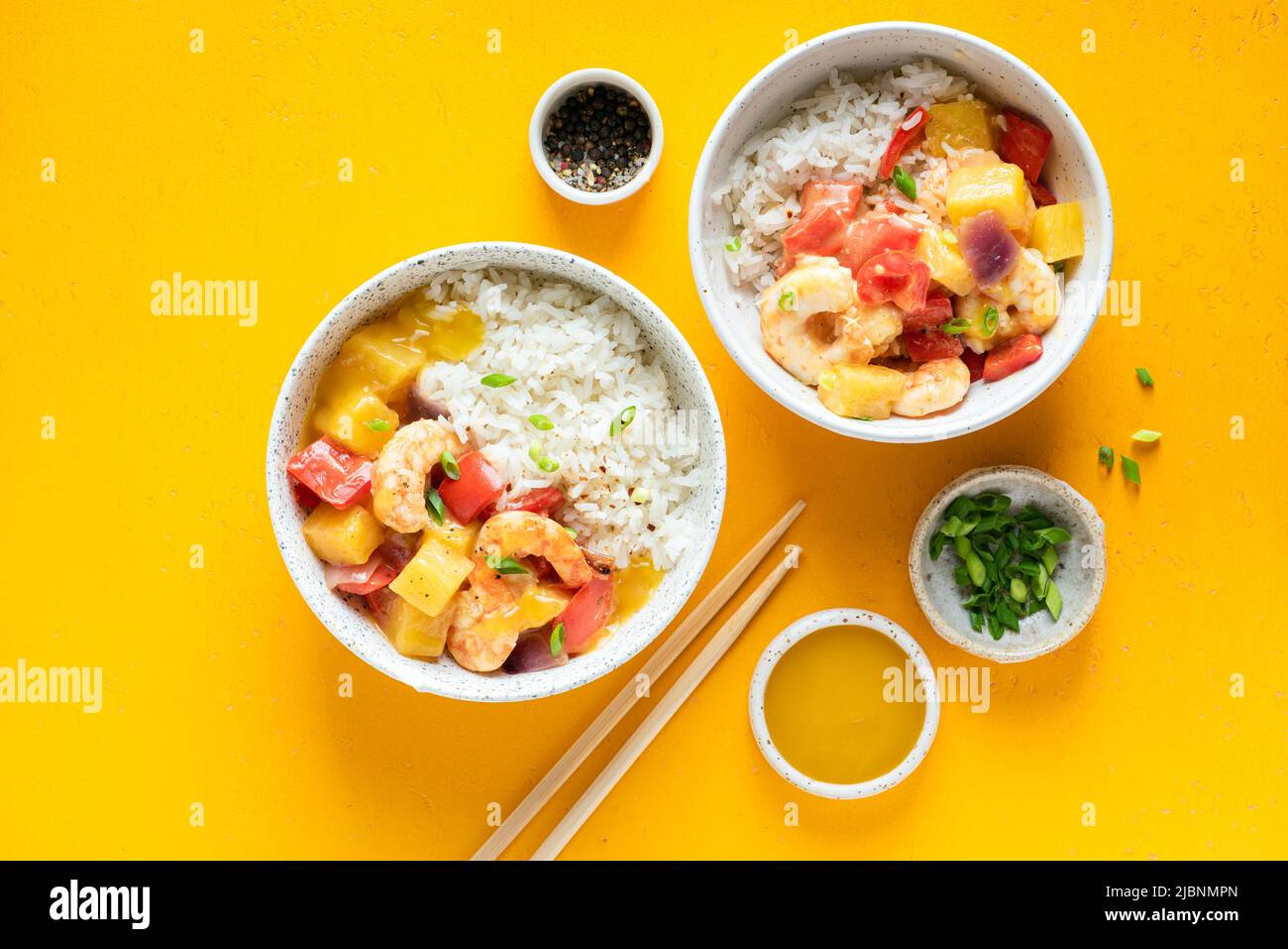 Ananas e gamberi al curry con riso bianco in ciotola su sfondo giallo. Vista dall'alto del tavolo. Cucina asiatica Foto Stock
