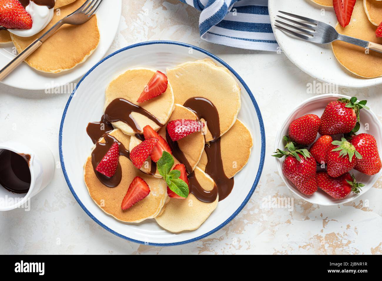 Pancake con fragola e cioccolato su un piatto, vista dall'alto. Colazione dolce Foto Stock