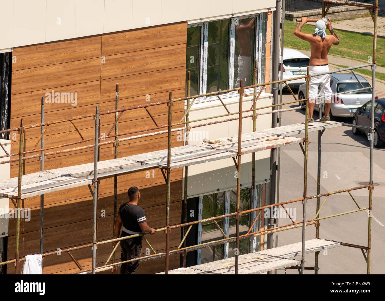 I lavoratori edili senza protezione smantellano il ponteggio di un edificio residenziale di recente costruzione a Sofia, Bulgaria, Europa orientale, Balcani, UE Foto Stock