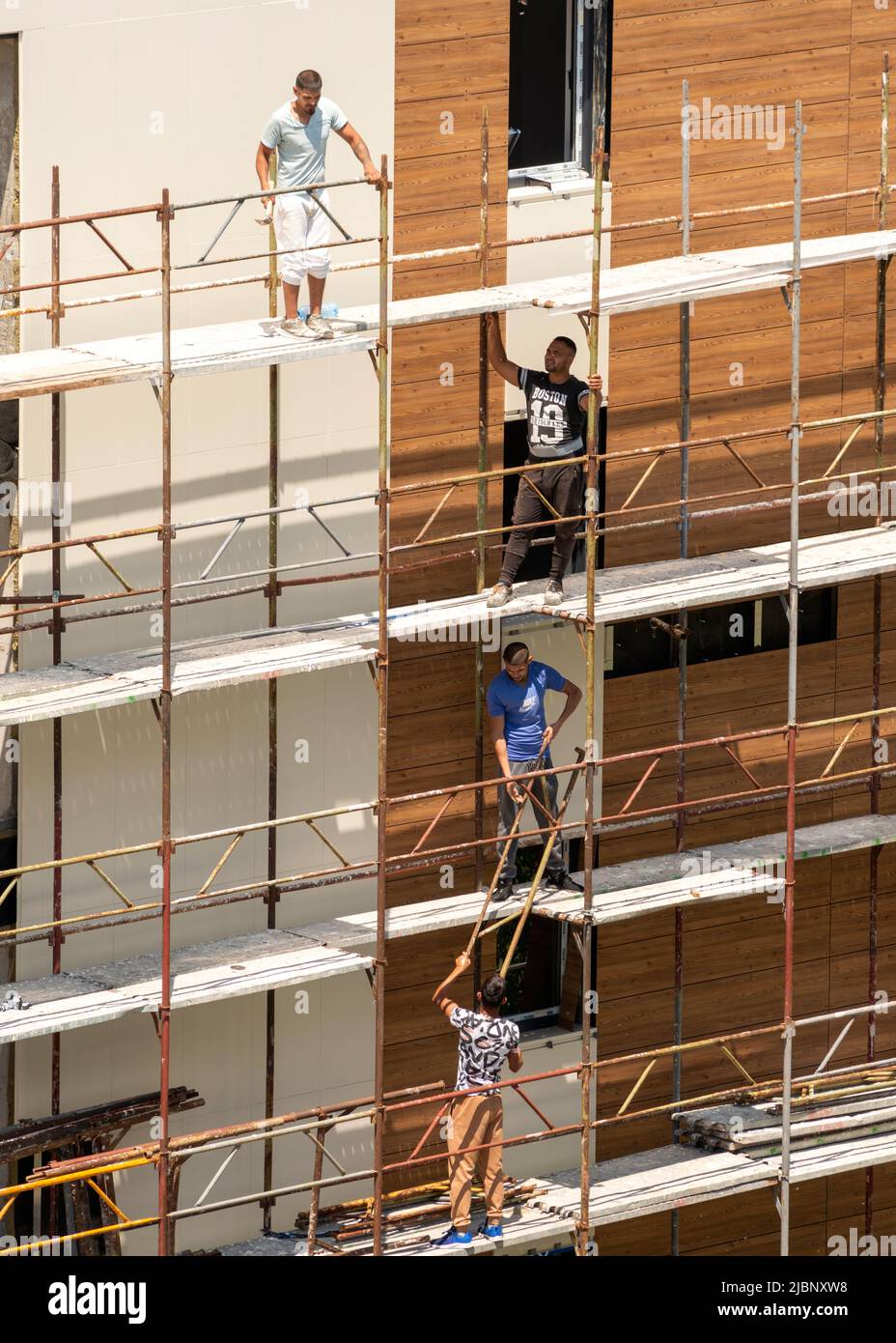 I lavoratori edili senza protezione smantellano il ponteggio di un edificio residenziale di recente costruzione a Sofia, Bulgaria, Europa orientale, Balcani, UE Foto Stock