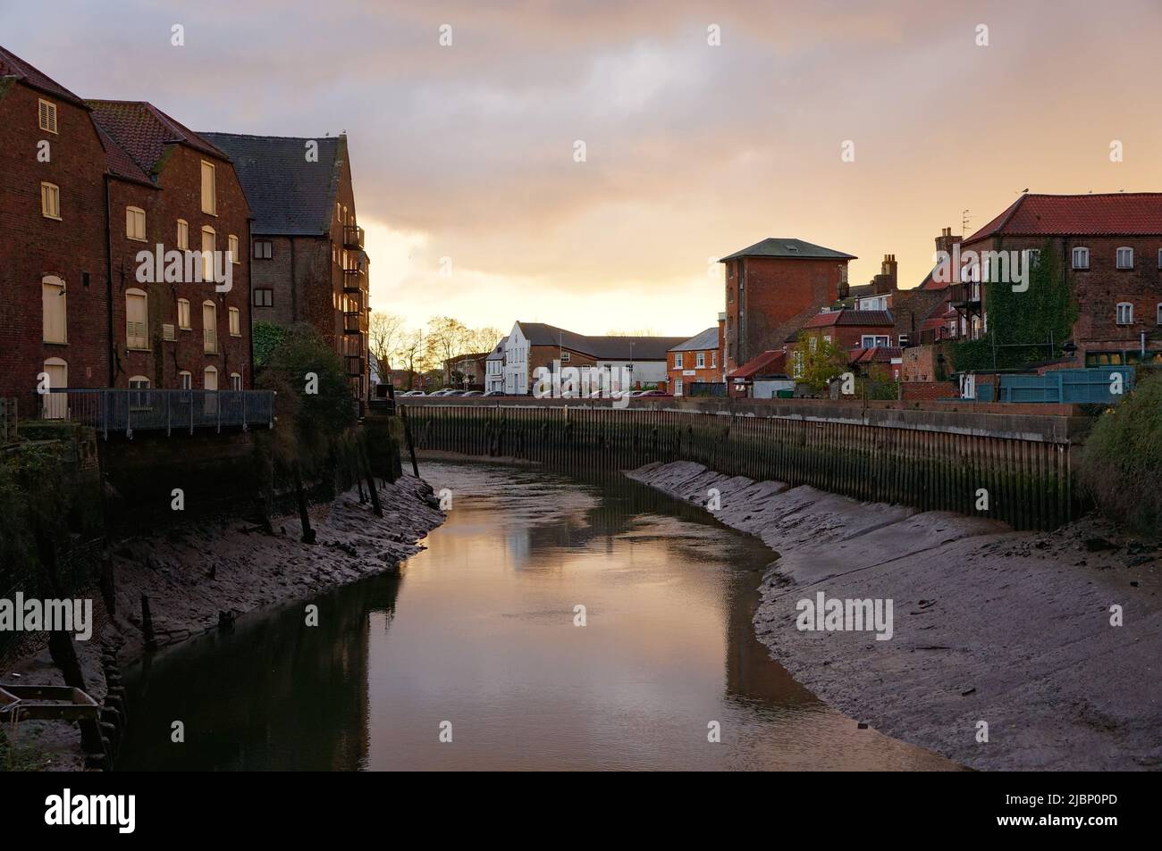 Il sole si getta attraverso un cielo coperto sopra South Quay, vicino al fiume Haven (Witham) con la bassa marea nel Lincolnshire di Boston Foto Stock